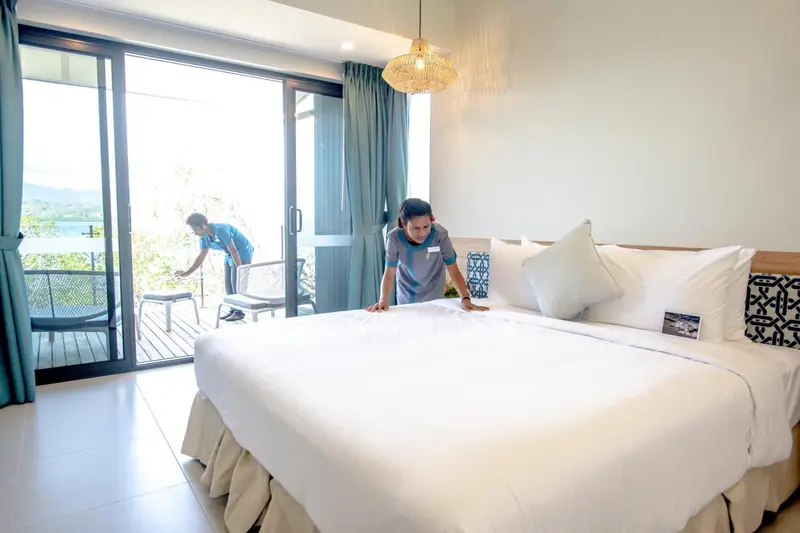 Une chambre lumineuse avec un grand lit et un accès à une terrasse.