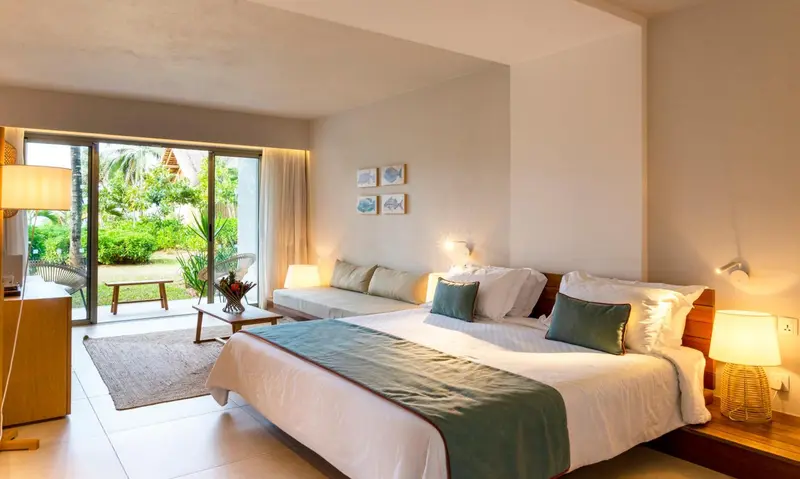 Une chambre lumineuse avec un grand lit et un accès à une terrasse.