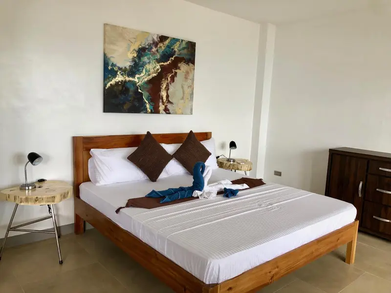 Une chambre lumineuse avec un grand lit et une décoration sobre.