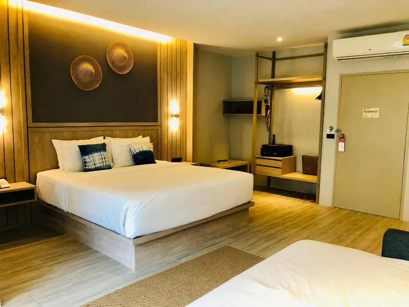 Une chambre lumineuse avec un grand lit recouvert d'une couette blanche.