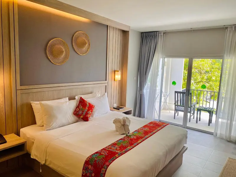 Une chambre lumineuse avec un grand lit et un accès à une terrasse.