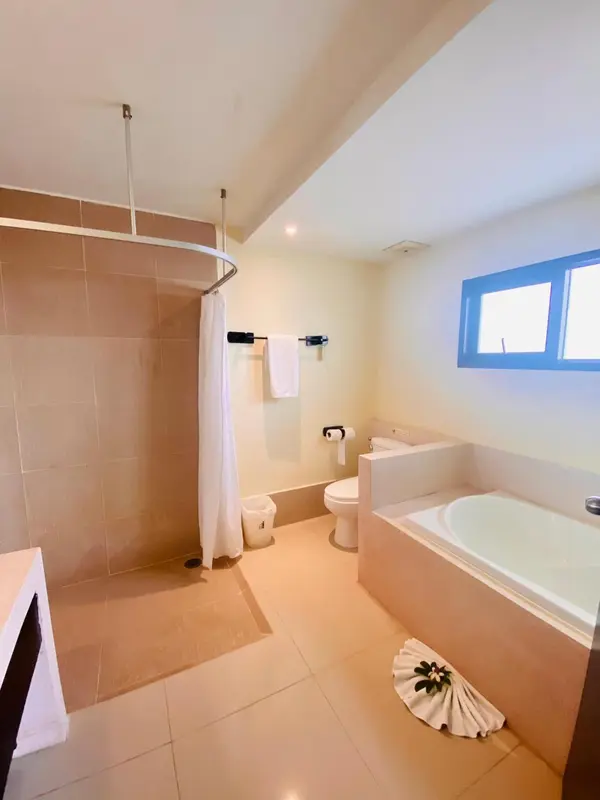 Une salle de bain lumineuse avec douche, baignoire et lavabo.
