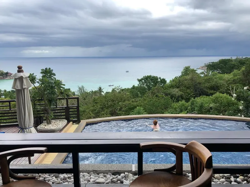 Une piscine à débordement offre une vue sur la mer et la végétation luxuriante.