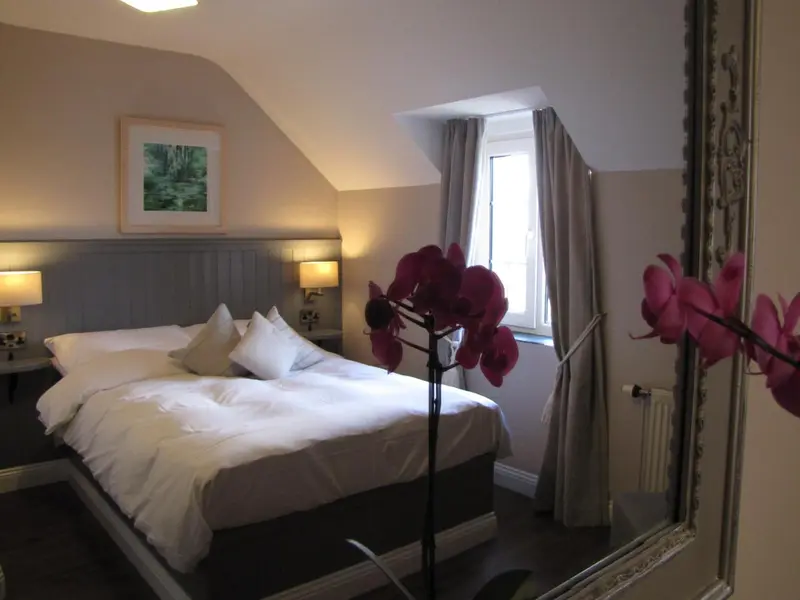 Une chambre lumineuse avec un grand lit et une décoration florale.