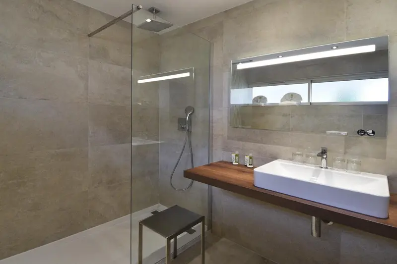 Une salle de bain moderne avec douche à l'italienne et vasque sur meuble.