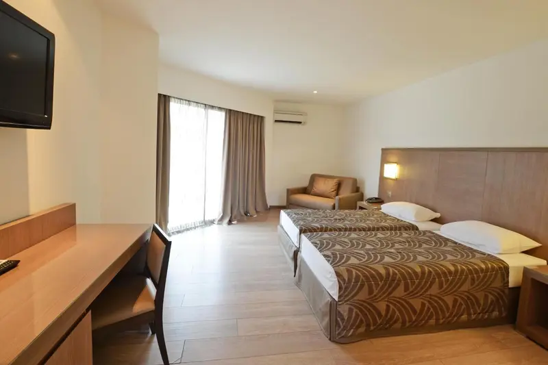 Une chambre lumineuse avec un lit double et un coin salon.