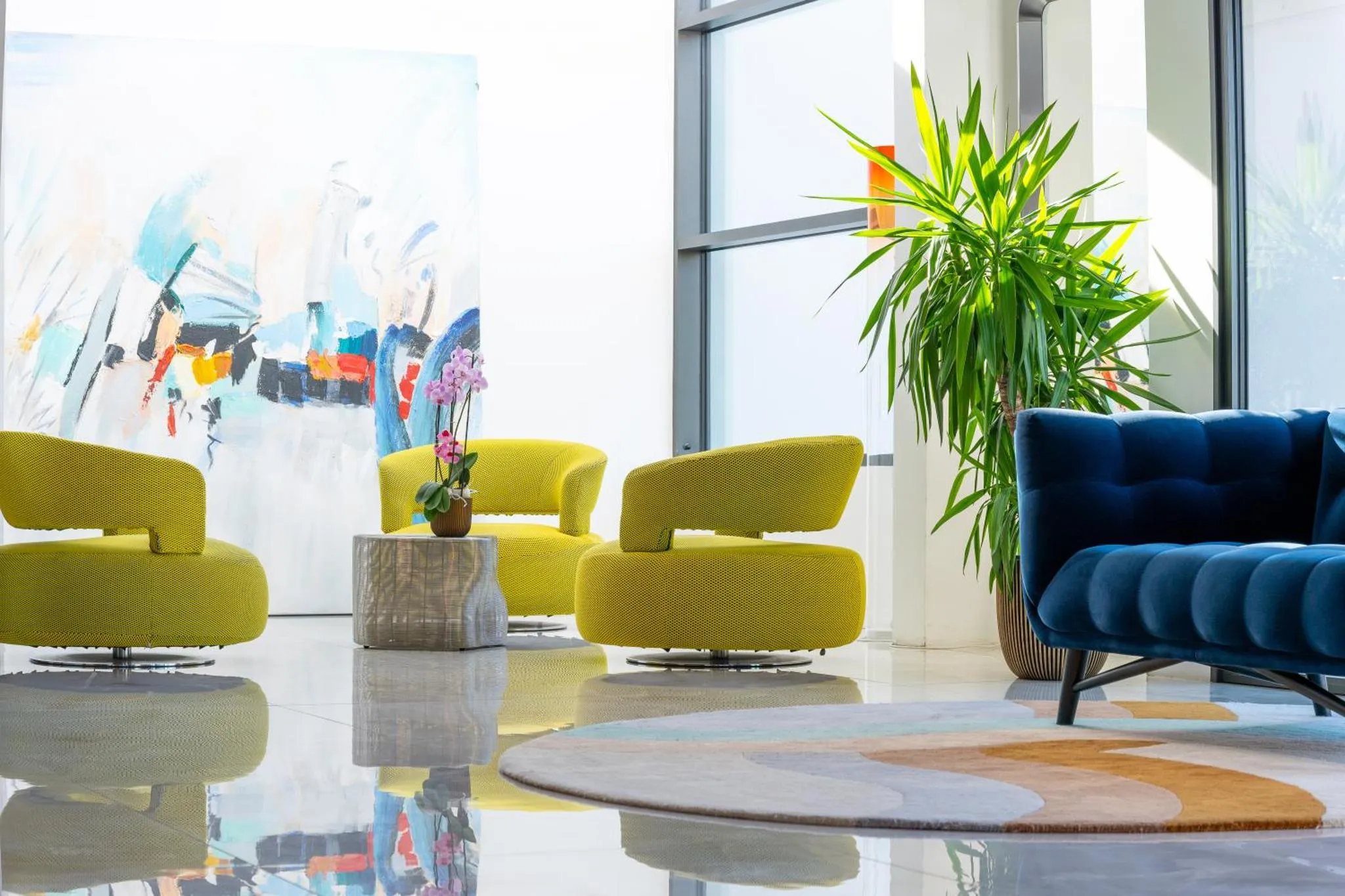 Un espace de détente intérieur avec des fauteuils colorés et une plante.