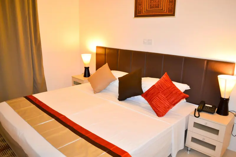 Une chambre lumineuse avec un grand lit recouvert d'une courtepointe colorée.