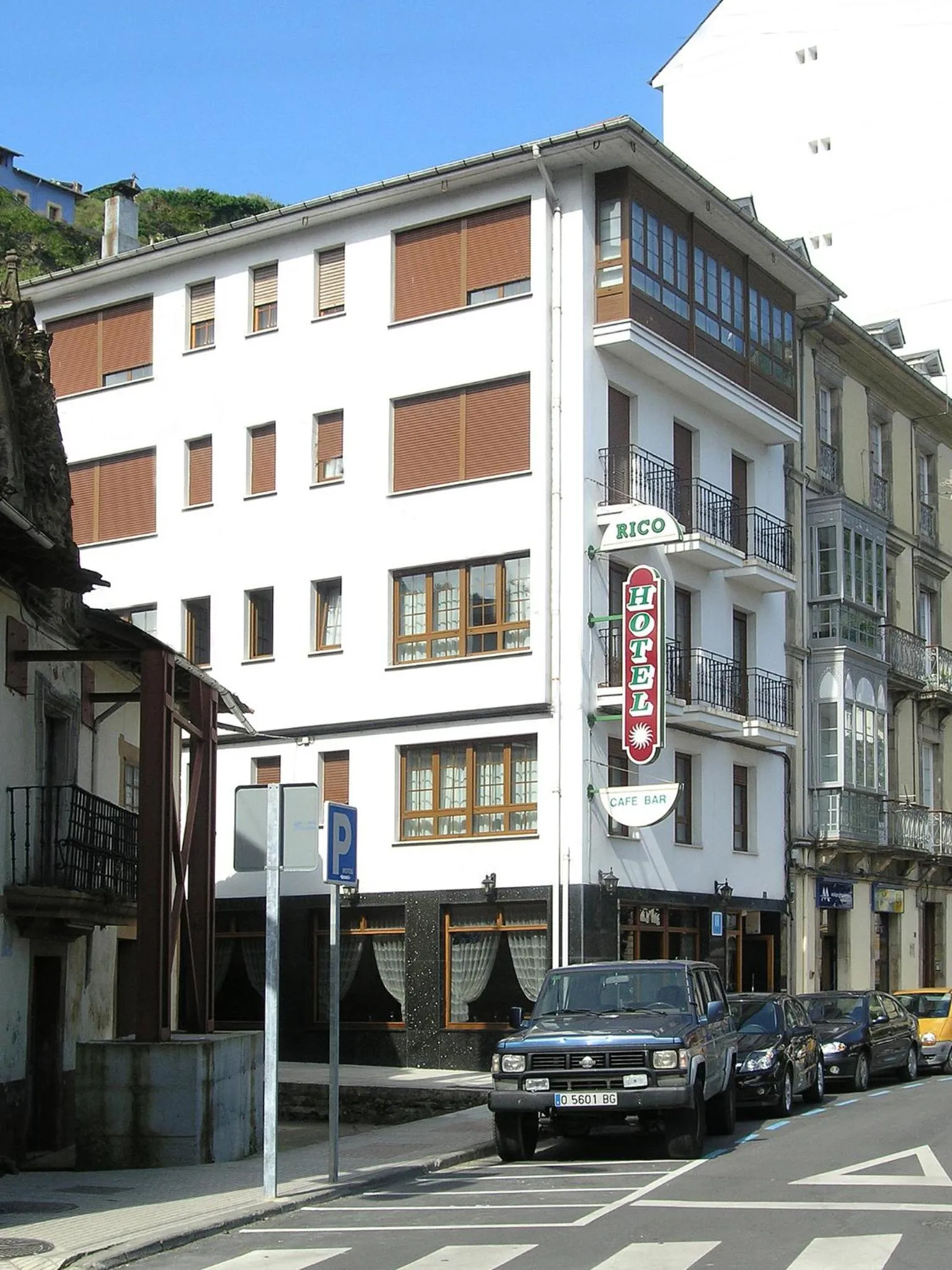Façade d'un bâtiment blanc avec des fenêtres et un café bar au rez-de-chaussée.