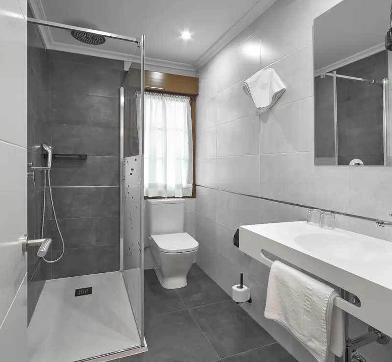 Une salle de bain moderne avec douche à l'italienne et lavabo.