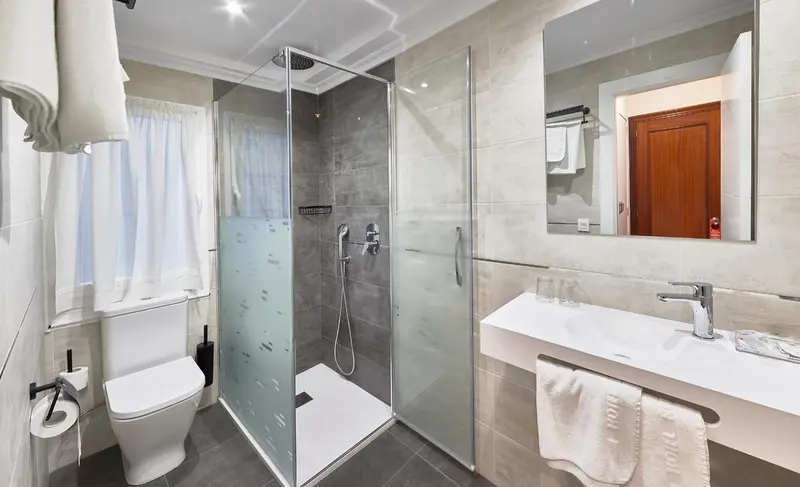 Une salle de bain moderne avec douche à l'italienne et lavabo.