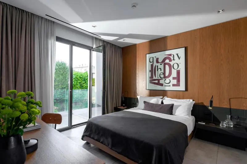Une chambre moderne avec un grand lit et un accès à un balcon.