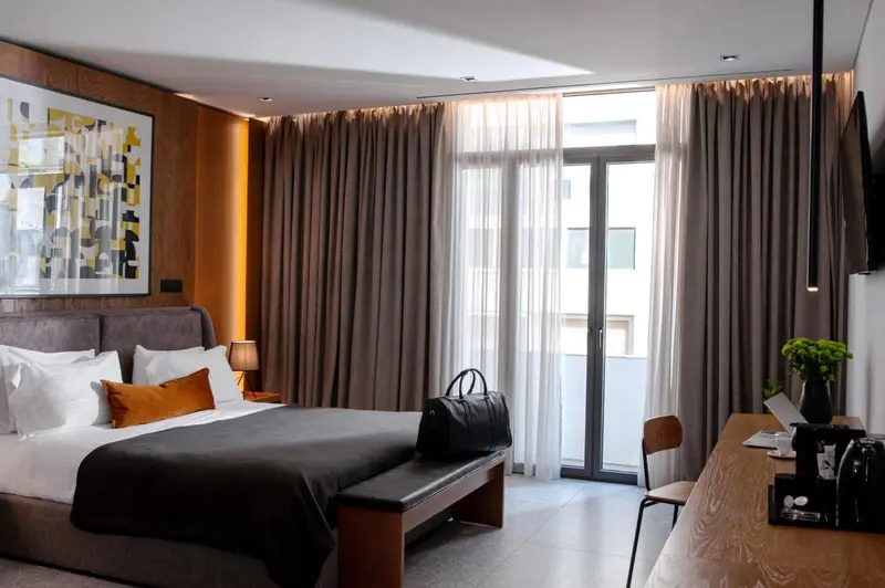 Une chambre moderne avec un grand lit et un accès à un balcon.