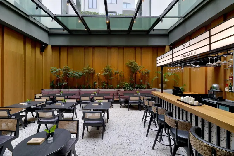 Un espace intérieur lumineux avec des tables, des canapés et un comptoir de bar.