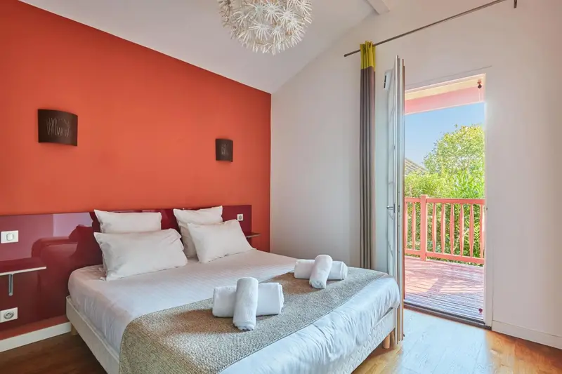 Une chambre lumineuse avec un grand lit et un accès à une terrasse.