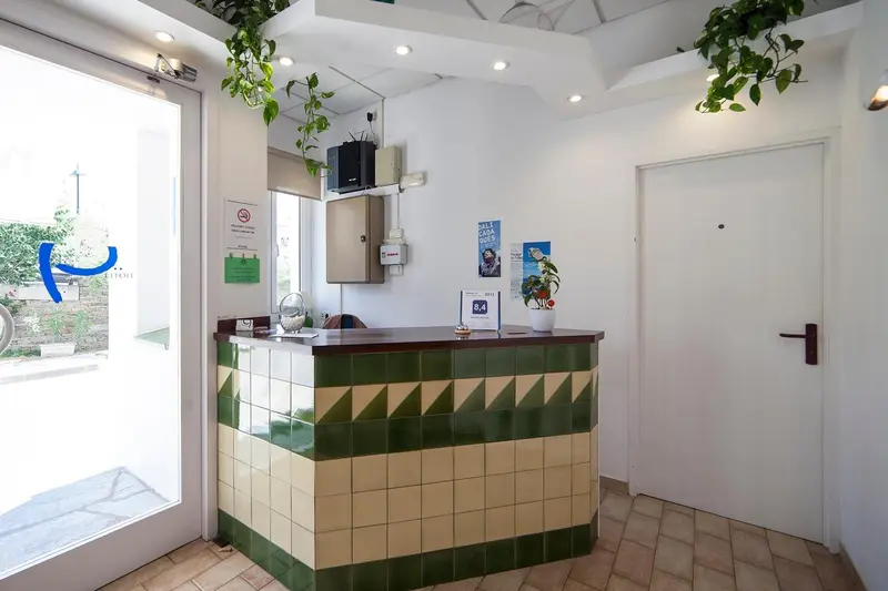 Un comptoir d'accueil avec un carrelage vert et blanc.