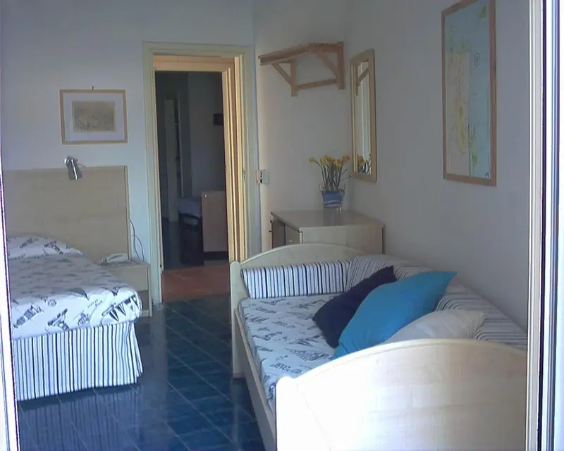Une chambre lumineuse avec deux lits et un canapé.