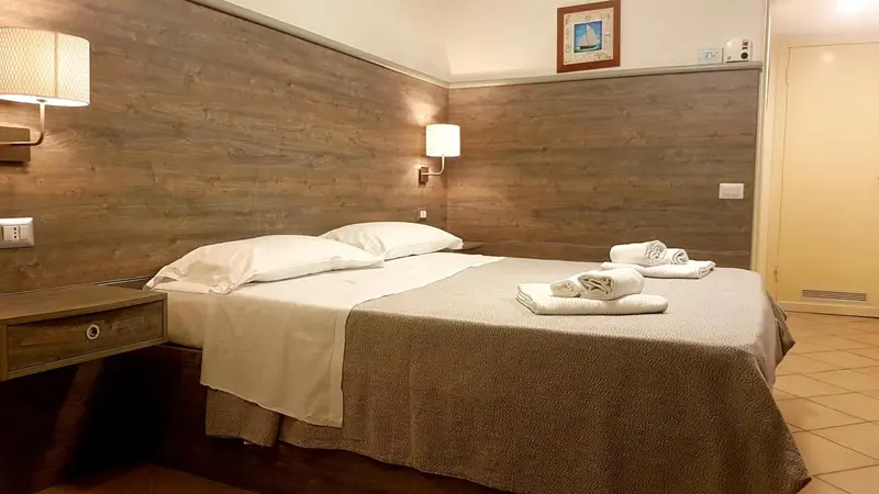 Une chambre avec un grand lit recouvert d'une courtepointe et de coussins.