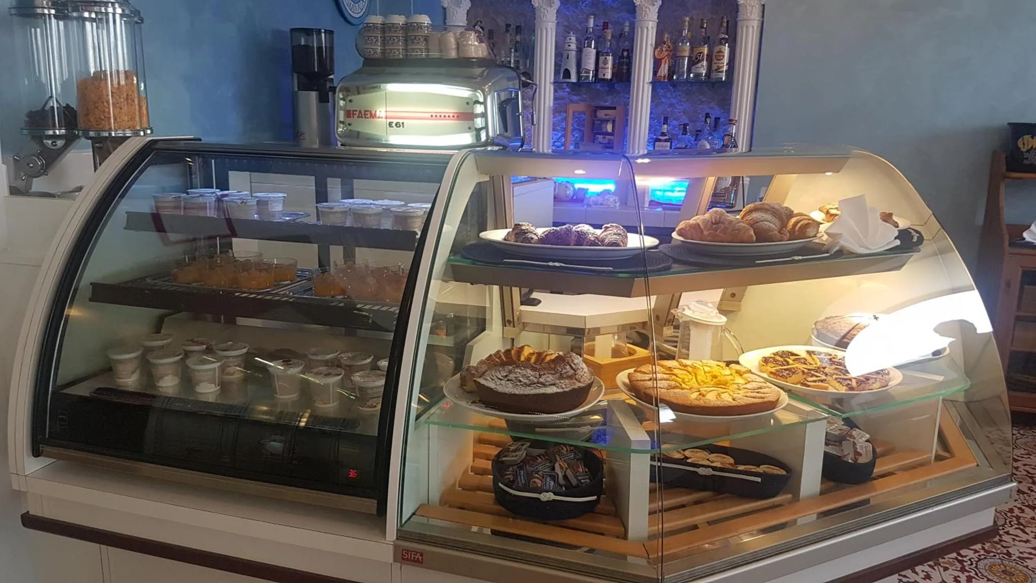 Présentation de pâtisseries et de viennoiseries dans une vitrine réfrigérée.