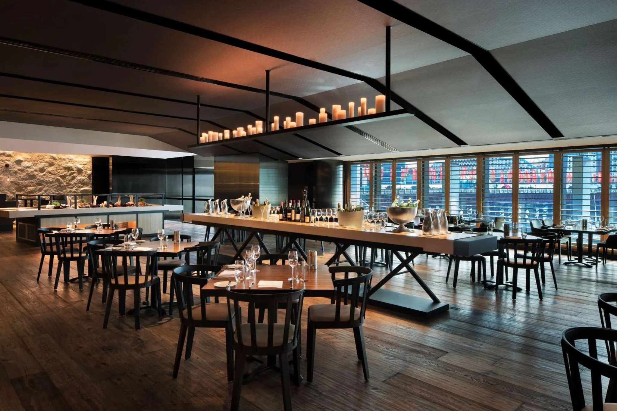 Une salle de restaurant moderne avec de longues tables en bois et des chaises.