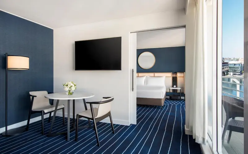Une chambre lumineuse avec un coin repas et un lit confortable.