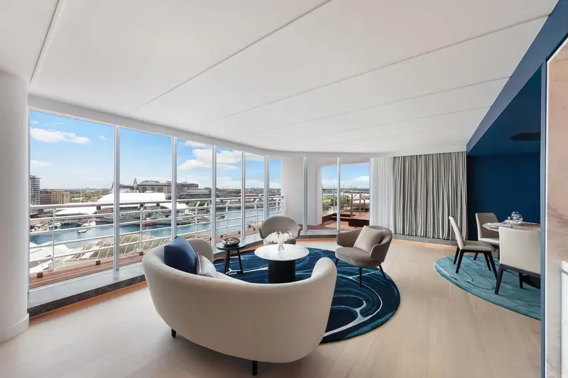 Espace de séjour lumineux avec canapés et vue sur le port.