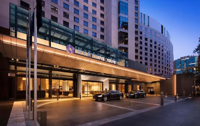 Façade d'un grand hôtel moderne illuminé au crépuscule.