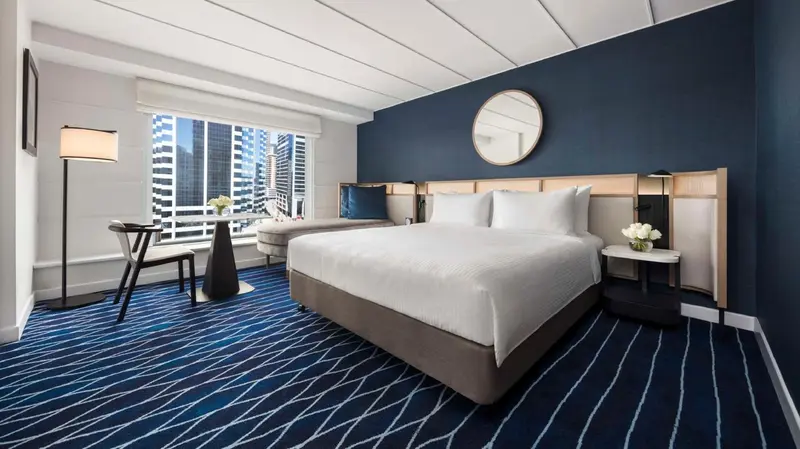 Une chambre d'hôtel moderne avec un grand lit et une vue sur la ville.