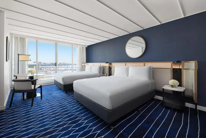 Chambre d'hôtel avec deux lits et vue sur la mer.