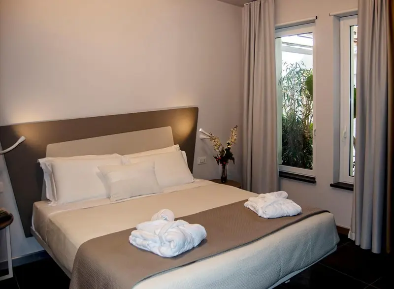 Une chambre avec un grand lit recouvert d'une couverture et de plusieurs oreillers.