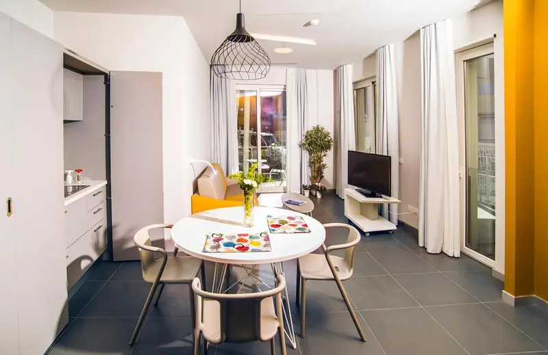 Espace de vie lumineux avec coin repas et accès à une terrasse.