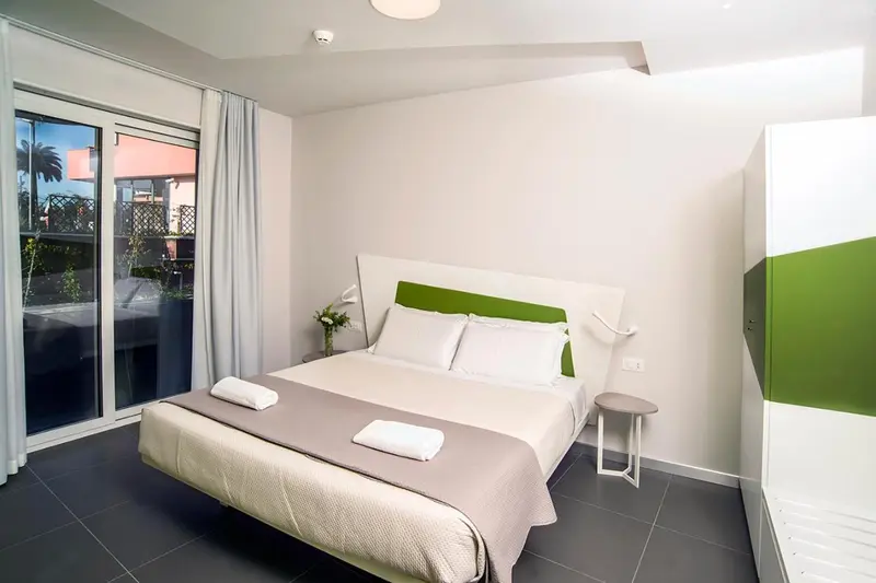 Une chambre lumineuse avec un grand lit et un accès à une terrasse.