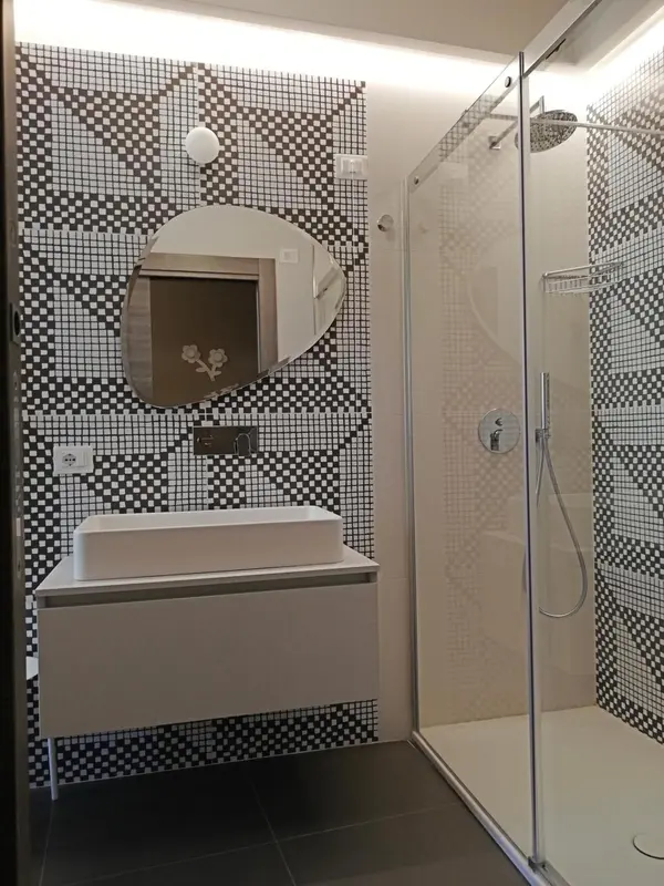 Une salle de bain moderne avec douche à l'italienne et lavabo intégré.