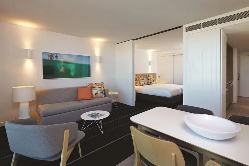 Espace de vie intérieur avec canapé, table basse et lit.