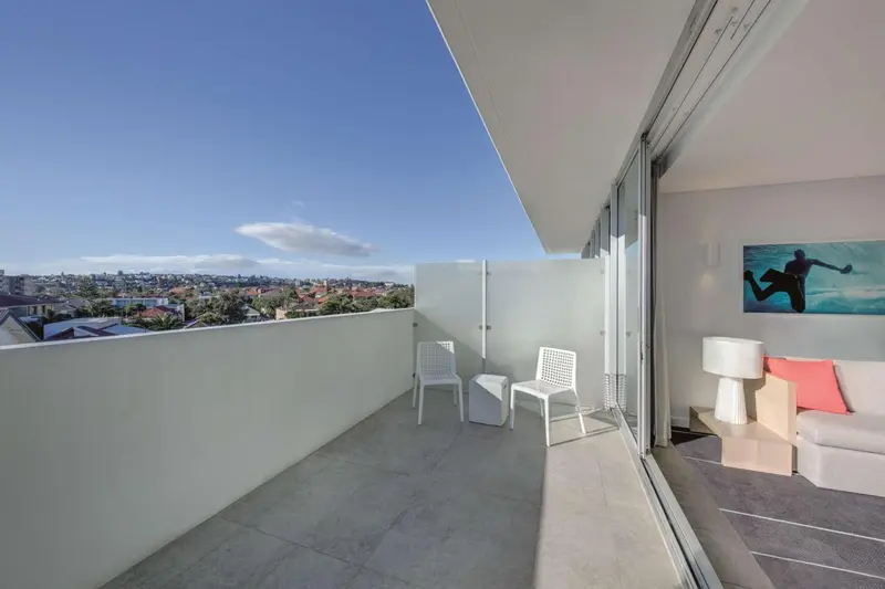 Terrasse moderne avec vue sur la ville et une œuvre d'art.
