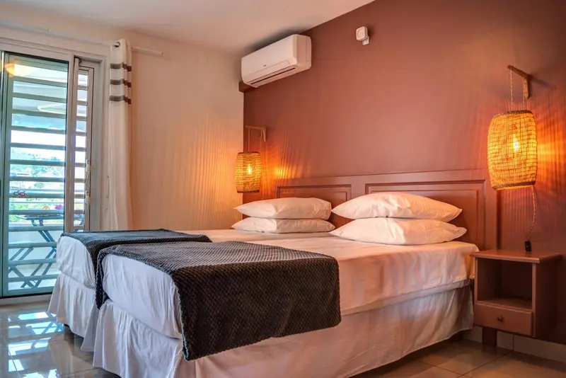 Une chambre lumineuse avec un grand lit et une vue sur l'extérieur.