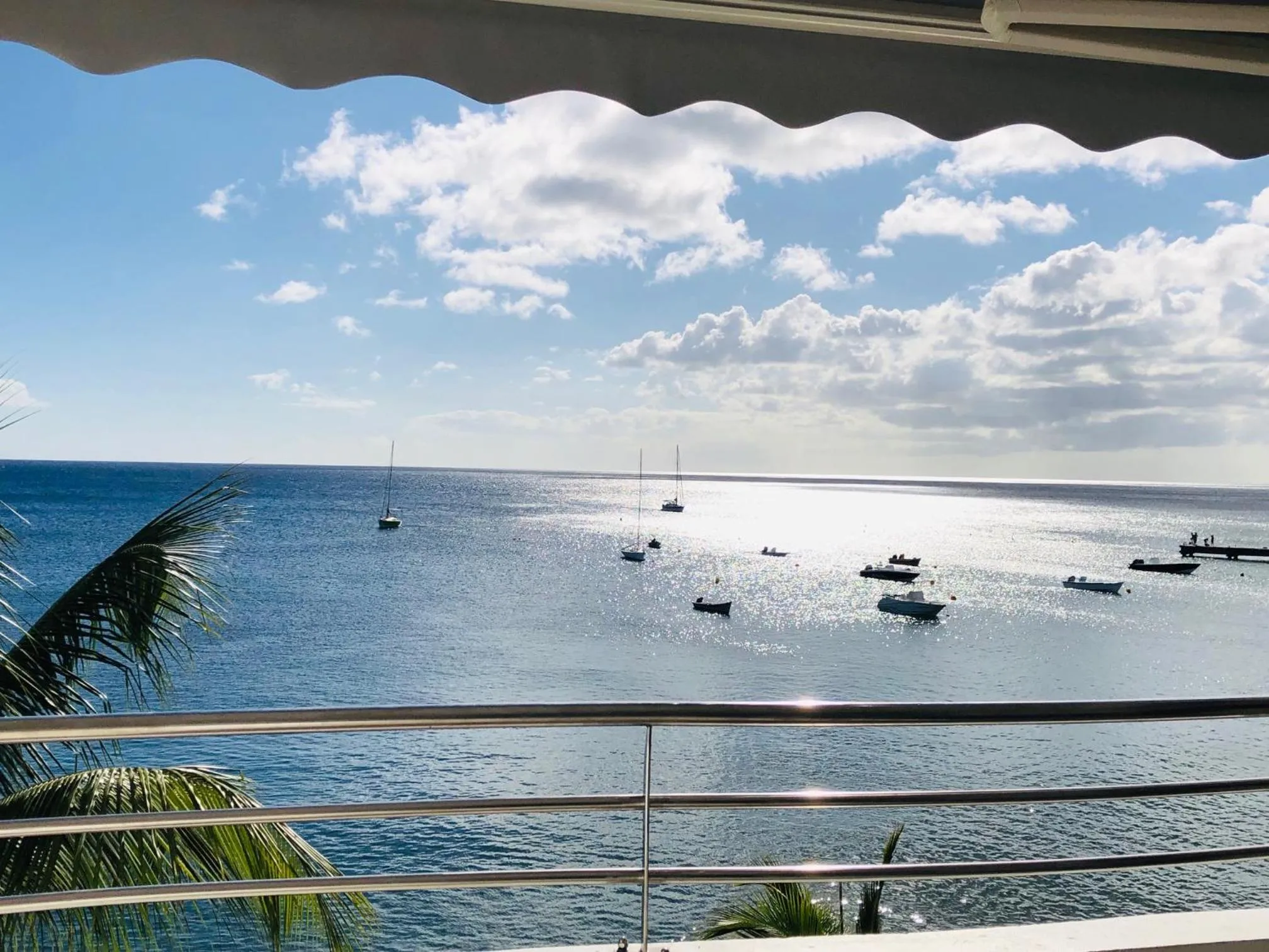 Vue sur la mer depuis une terrasse ensoleillée.