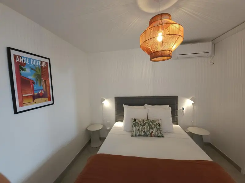 Une chambre lumineuse avec un grand lit et une décoration murale.