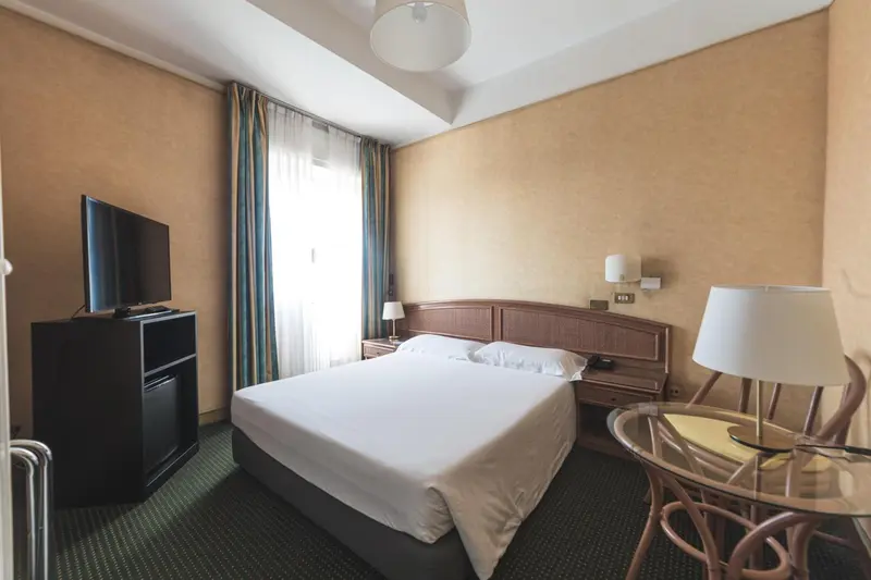 Une chambre lumineuse avec un lit double et une table basse.