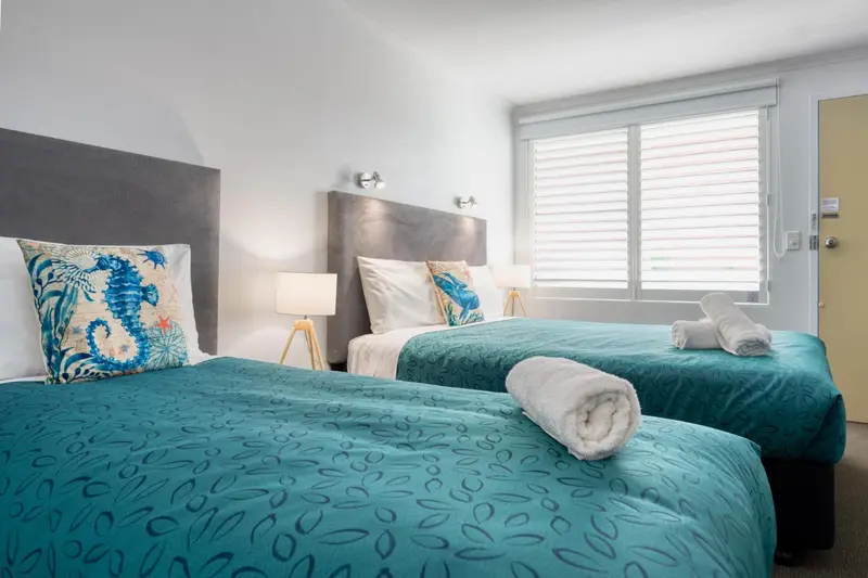 Chambre avec deux lits simples et une décoration marine.