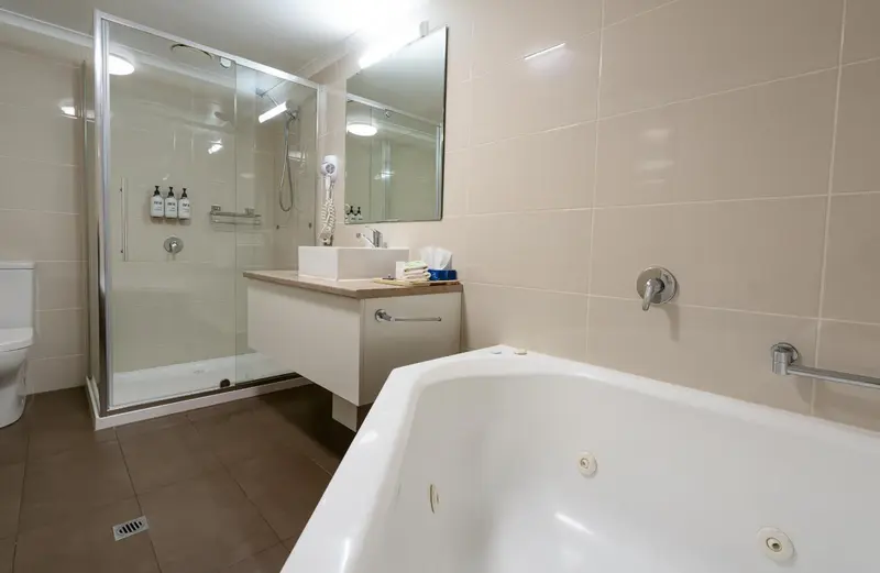 Une salle de bain claire avec douche à l'italienne et baignoire.