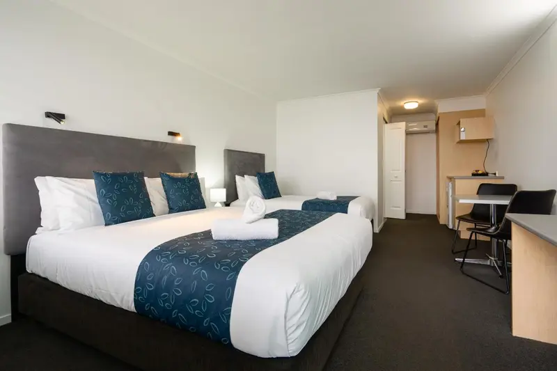 Une chambre lumineuse avec un grand lit et un coin repas.