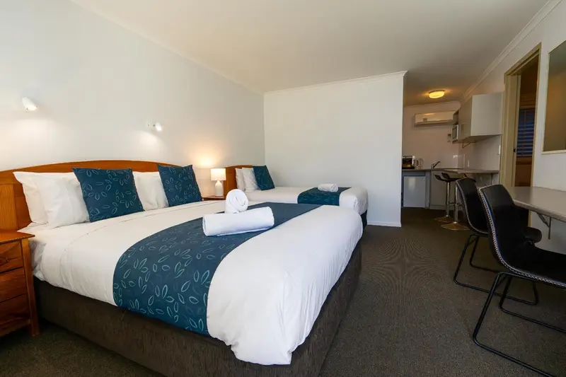 Chambre avec un grand lit et un coin repas.