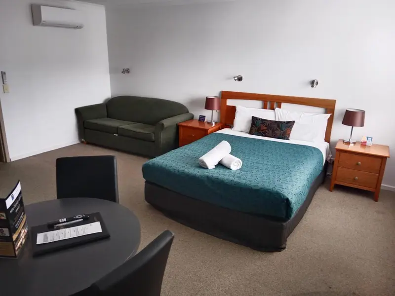 Une chambre avec un lit double et un canapé vert.