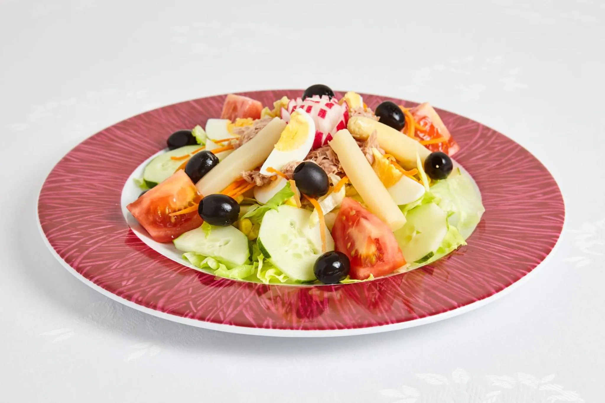 Assiette de salade composée avec des légumes variés et des olives.
