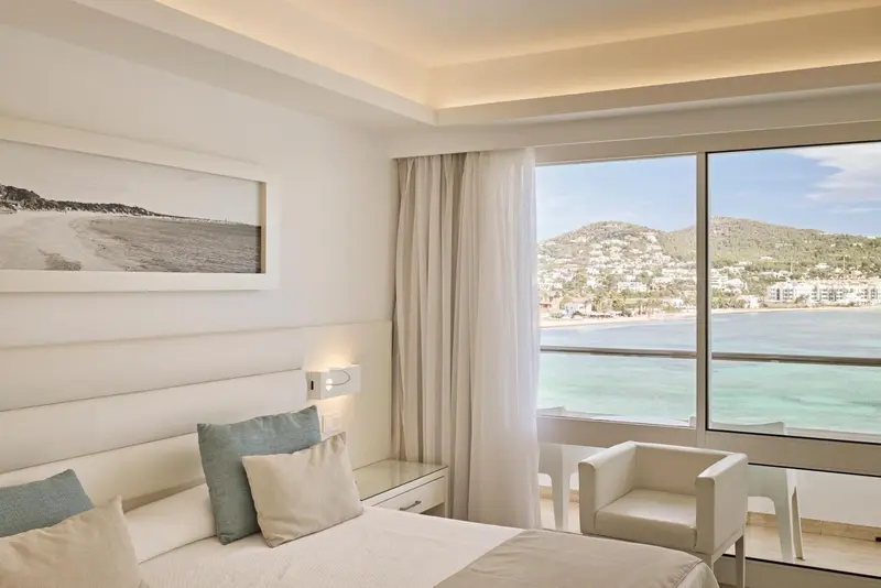 Une chambre lumineuse avec vue sur la mer et les montagnes.