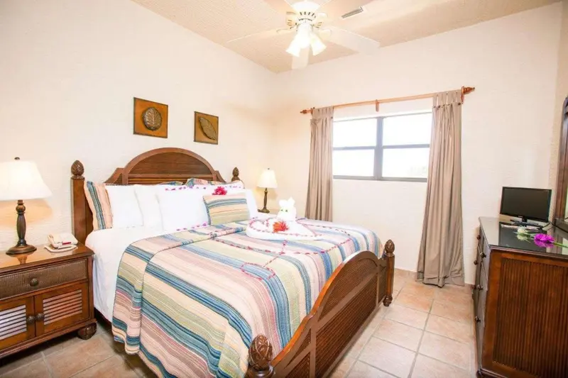 Une chambre lumineuse avec un grand lit recouvert d'une courtepointe colorée.