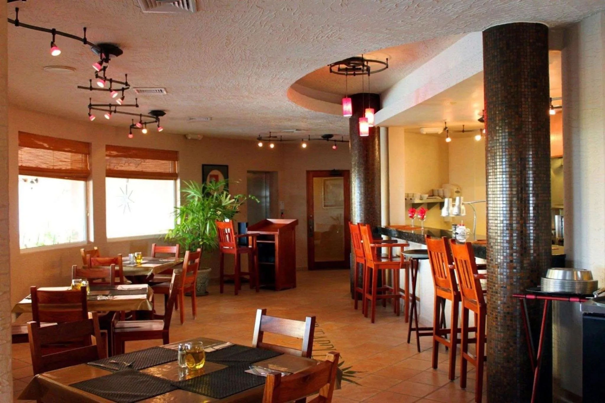Une salle de restaurant lumineuse avec des tables et un comptoir.