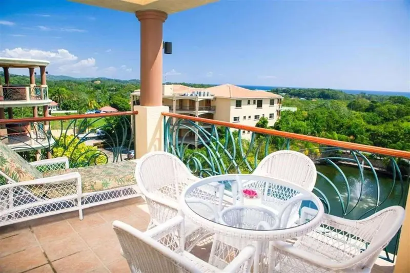 Terrasse avec mobilier blanc donnant sur une vue panoramique.