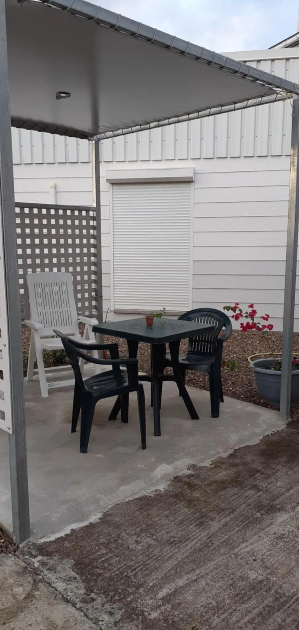 Une table et des chaises se trouvent sur une terrasse carrelée.